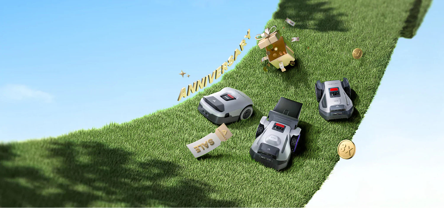 ANTHBOT robot lawn mowers on a grassy lawn with anniversary gift boxes and a festive outdoor display