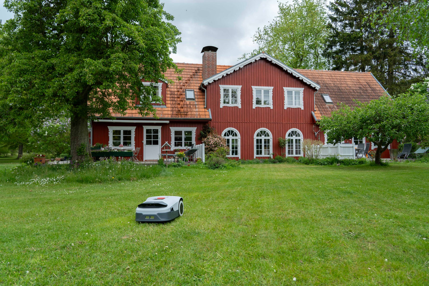 A robot lawn mower is working on a large lawn.